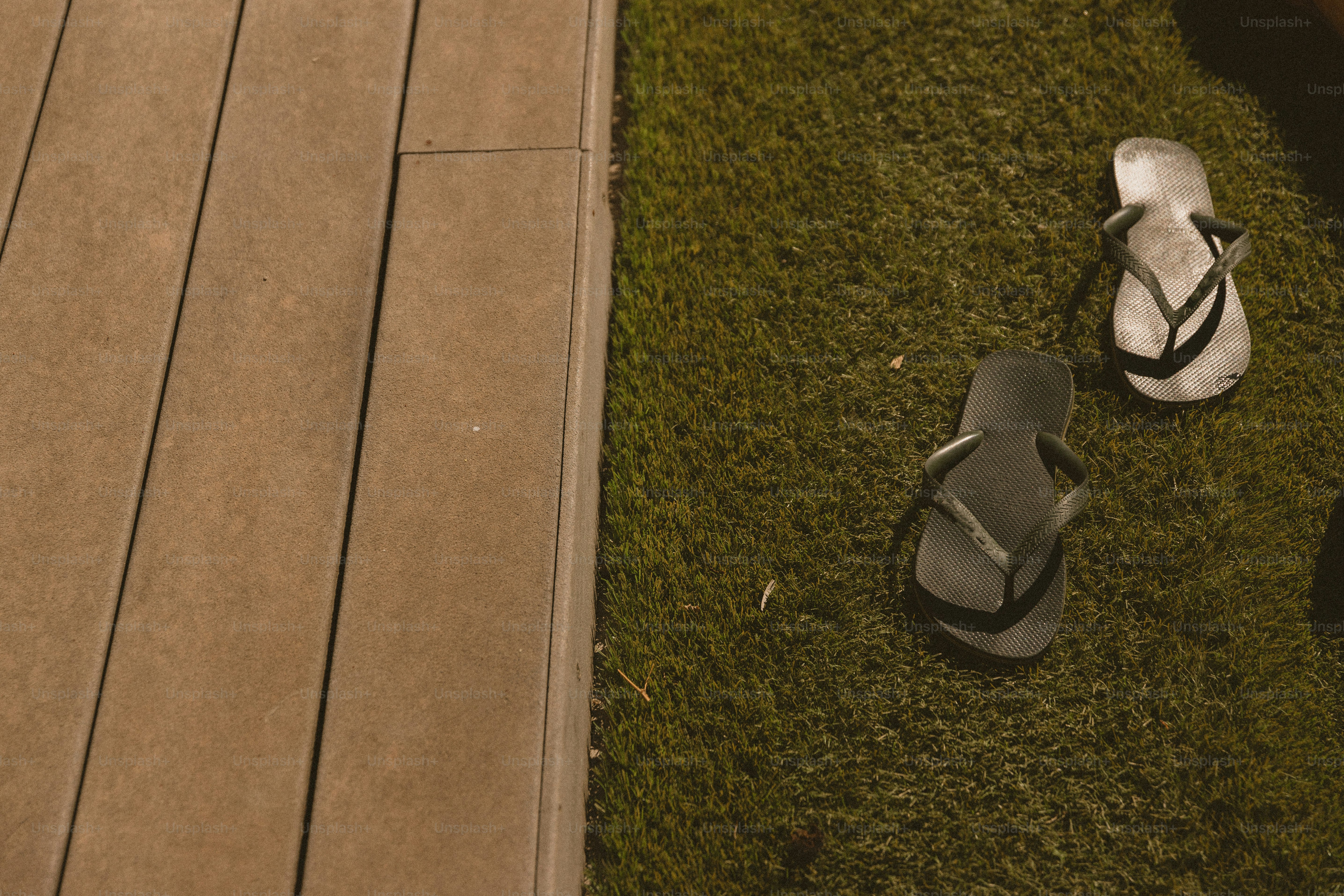 A pair of flip flops sitting on top of a wooden deck
